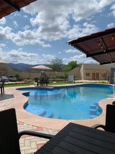 - une grande piscine avec une table et un parasol dans l'établissement Hotel y Restaurante Villas Del Sol Jalpan, à Jalpan de Serra