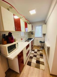 una pequeña cocina con fregadero y microondas en A's apartment, en Onești