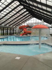 a swimming pool with a water slide in a building at Grand Smokies Resort Lodge Pigeon Forge in Pigeon Forge