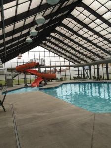 a swimming pool with a slide in a building at Grand Smokies Resort Lodge Pigeon Forge in Pigeon Forge