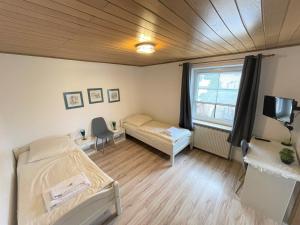 Zimmer mit 2 Betten und einem Fenster in der Unterkunft Ellada Restaurant & Hotel in Tarp
