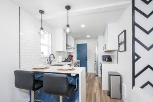 een keuken met witte muren en een aanrecht met stoelen bij Beautiful Remodeled Home 3 BD 1 BTH w Hot Tub in Spokane Valley