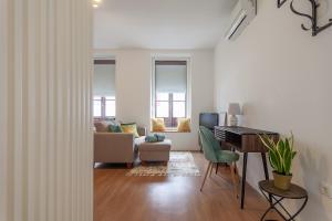 a living room with a desk and a couch at Casa Esmeralda by Home Sweet Home Aveiro in Aveiro