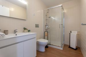 a bathroom with a shower and a toilet and a sink at Casa Esmeralda by Home Sweet Home Aveiro in Aveiro +14 photos