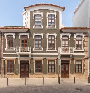 a green building with brown doors and windows at Casa Esmeralda by Home Sweet Home Aveiro in Aveiro