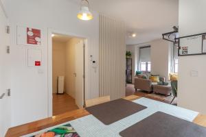 a living room with a couch and a room with a rug at Casa Esmeralda by Home Sweet Home Aveiro in Aveiro