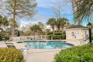 a large swimming pool with chairs and trees at Riverwalk 301 in Myrtle Beach