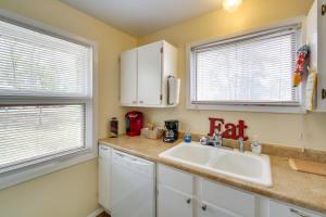 a kitchen with a sink and two windows at Cozy Lake Cabin with Dock in Hot Springs Natl Park in Lake Hamilton +21 photos
