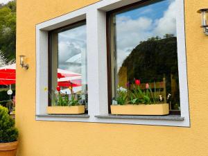 due finestre con fiori in un edificio di Hotel Cafe Restaurant Loreleyblick a Sankt Goar