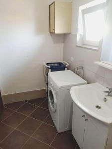 a bathroom with a washing machine and a sink at Apartment Prvic Sepurine II in Prvić Šepurine