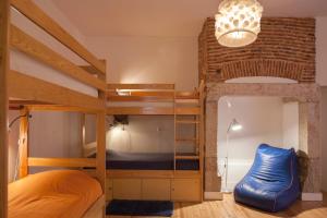 Zimmer mit 2 Etagenbetten und einem blauen Sofa in der Unterkunft Lisbon Lounge Hostel in Lissabon