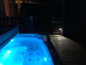 a jacuzzi tub on a deck at night at Le Mill in Meilhan