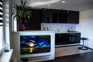 a kitchen with a flat screen tv in a living room at Valmiera in Valmiera