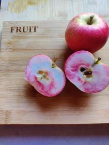 dos manzanas en una tabla de cortar de madera con la palabra fruta en Park Hill Pod en Stratford-upon-Avon