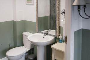 bagno con servizi igienici bianchi e lavandino di BroomHouse HomeStay a Edimburgo