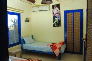 a small bedroom with a small bed and a window at Kamariat Tunis Bay in Kafr ‘Amr