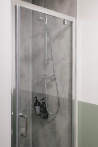 una ducha con 2 botellas en una cabina de ducha en BroomHouse HomeStay, en Edimburgo