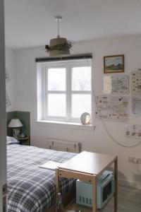 um quarto com uma cama, uma televisão e uma janela em BroomHouse HomeStay em Edinburgo