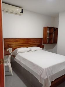 een slaapkamer met een wit bed en een bureau met een raam bij HOTEL SAN ADOLFO in Apartadó