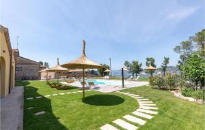 een tuin met parasols en een zwembad bij Cozy Home In Santarcangelo With Sauna in Sant Arcangelo