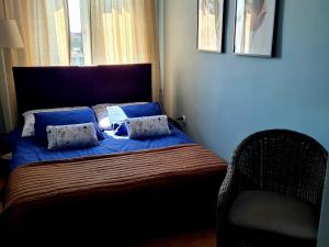 a bedroom with a bed with blue sheets and a window at Apartament Mazury in Giżycko