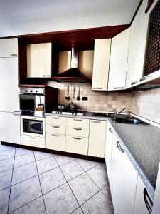 a kitchen with white cabinets and white appliances at Welcome Traveller CHARMING EVA APARTMENT in Garda