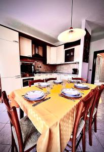 a kitchen with a table with a yellow table cloth at Welcome Traveller CHARMING EVA APARTMENT in Garda
