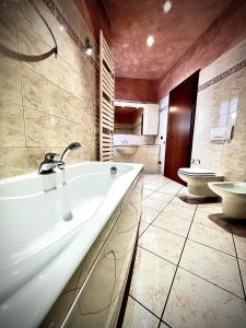 a bathroom with a tub and a toilet at Welcome Traveller CHARMING EVA APARTMENT in Garda