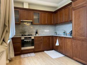 a kitchen with wooden cabinets and a stove top oven at Eksporta Street Quiet Old Riga Apartment in Rīga