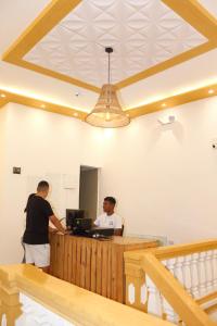 two men standing at a desk in a room at Hostal Casa Torres Cartagena Centro Historico - Adults Only in Cartagena de Indias