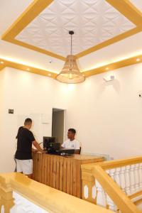 two men standing at a desk in a room at Hostal Casa Torres Centro Historico - Adults Only in Cartagena de Indias