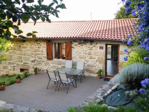 a patio with a table and chairs in front of a house at Casa Rural en Pontevedra in Sacos
