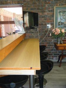 a desk with chairs and a television in a room at SEA WAY SELFCATERING ACCOMMODATION BETTYS BAY in Bettyʼs Bay +5 photos