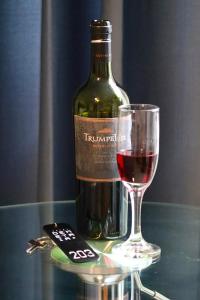 uma garrafa de vinho e um copo sobre uma mesa em Hotel Demetria em Huánuco