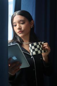 a woman holding a tablet computer in her hands at Hotel Demetria in Huánuco