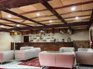 a large room with white chairs and a bar at Hotel Meteorites Boulaajoul in Zaida