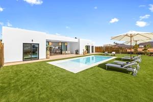 a backyard with a swimming pool and grass at Villa Ayala in Villaverde