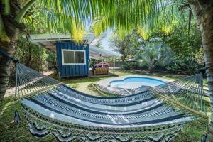 a hammock in front of a house with a pool at Cute, modern Tiny home with pool for 2 people in Playa Potrero in Potrero