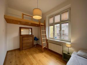 1 dormitorio con litera, escalera y ventana en Apartamenty Zasanie, en Przemyśl