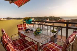 a table and chairs on a balcony with a view at Apartmani Soldan in Makarska