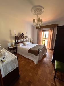 een slaapkamer met een groot bed en een kroonluchter bij Casa Vicente in Lamego