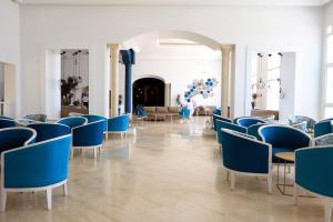 Hotel Riad Meninx Djerba في Djerba: غرفة مليئة بالكراسي الزرقاء والطاولات