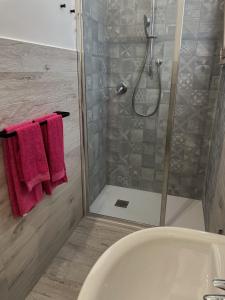 ein Badezimmer mit einer Badewanne und einer Dusche mit roten Handtüchern in der Unterkunft Il mandorlo appartamenti in San Vito Chietino