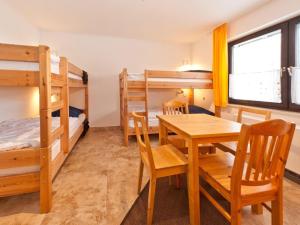 a room with bunk beds and a table and chairs at Holiday home Reichenbach in Bayerstetten