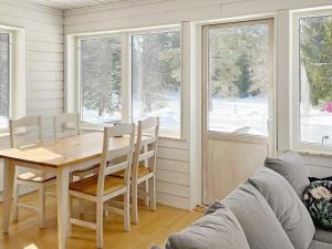 - une salle à manger avec une table, des chaises et des fenêtres dans l'établissement Two-Bedroom Holiday home in Norrtälje, à Marholmen