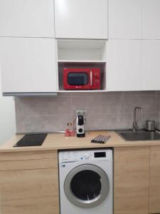 a kitchen with a washing machine and a microwave at Cruz Verde - Centro Histórico - Vivienda Vacacional in Santa Cruz de Tenerife