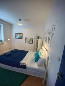 una camera da letto con letto con lenzuola blu e cuscini blu di Boho Studio - Brno Cejl a Brno