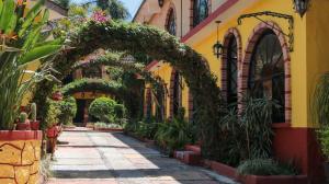 an entrance to a building with an arch and potted plants at Ideal Ixtapan in Ixtapan de la Sal