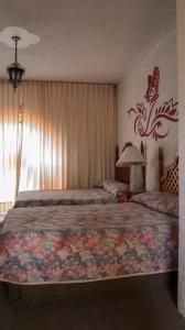 - une chambre avec un grand lit et une couverture colorée dans l'établissement Ideal Ixtapan, à Ixtapan de la Sal