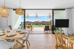 a dining room with a table and chairs and a tv at Villa Ayala in Villaverde